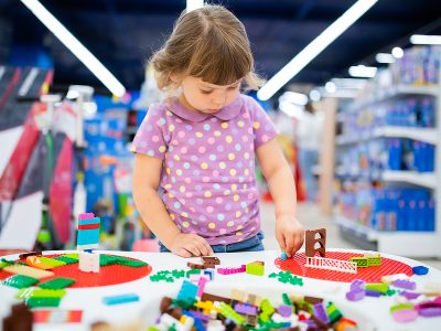 RUSSIA, Moscow. July 03, 2018. Adorable llittle girl playing with plastic lego brick constructor. Early education and development.